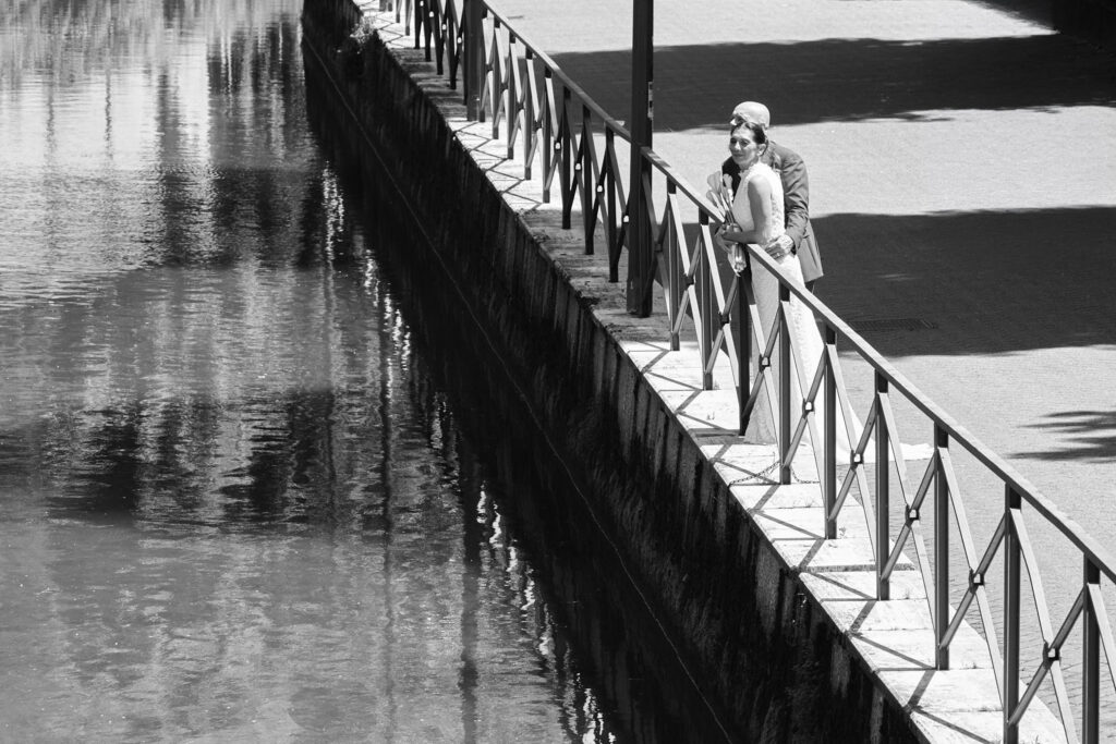 Bride and groom walking beside the water on their wedding day