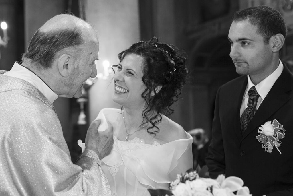 Bride laughing during the wedding ceremony with the groom beside her