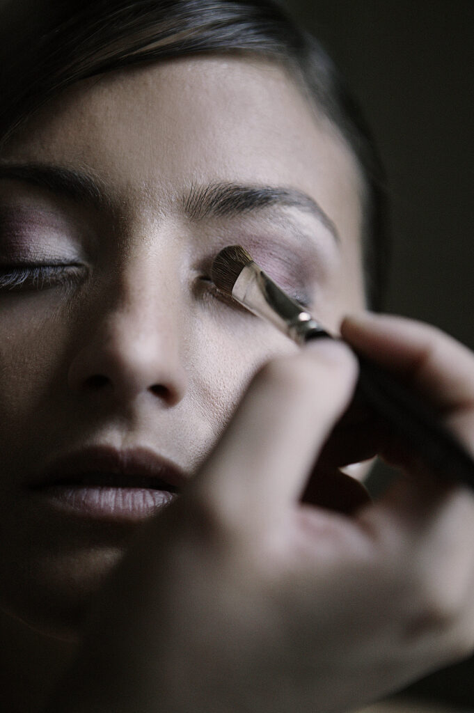 Bride having her eye makeup applied before the wedding ceremony