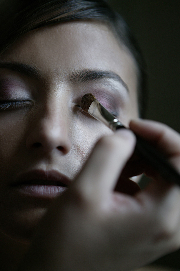 Bride having her makeup applied before the wedding ceremony