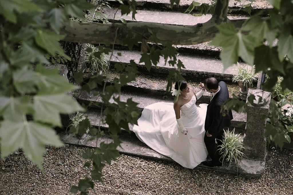 Bride and groom photographed from above through the leaves on their wedding day