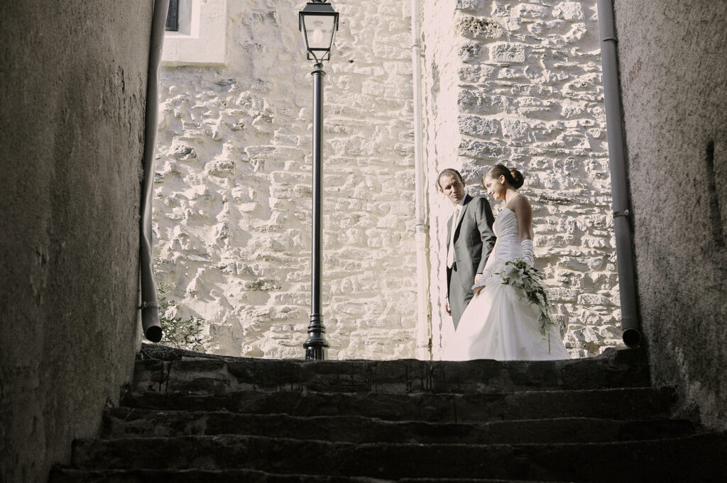Bride and groom framed by stone walls on their wedding day