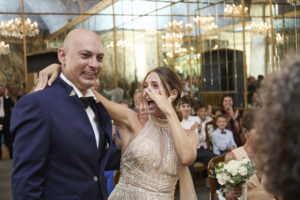 Bride wiping away tears after exchanging wedding rings with the groom