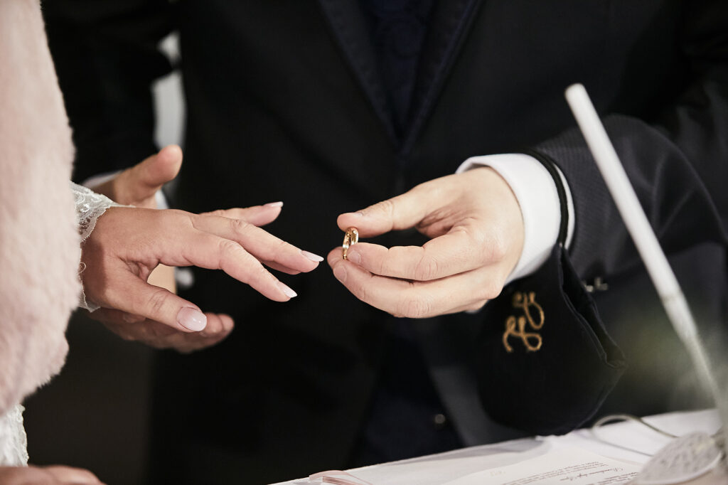 Groom placing the wedding ring on the bride's finger during the ceremony