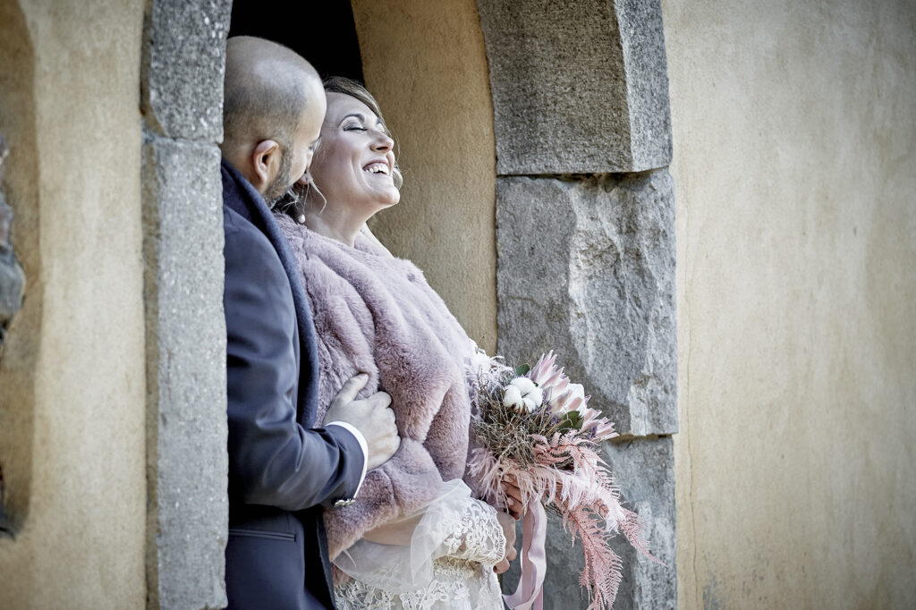 Bride laughing in the groom's arms after the wedding ceremony